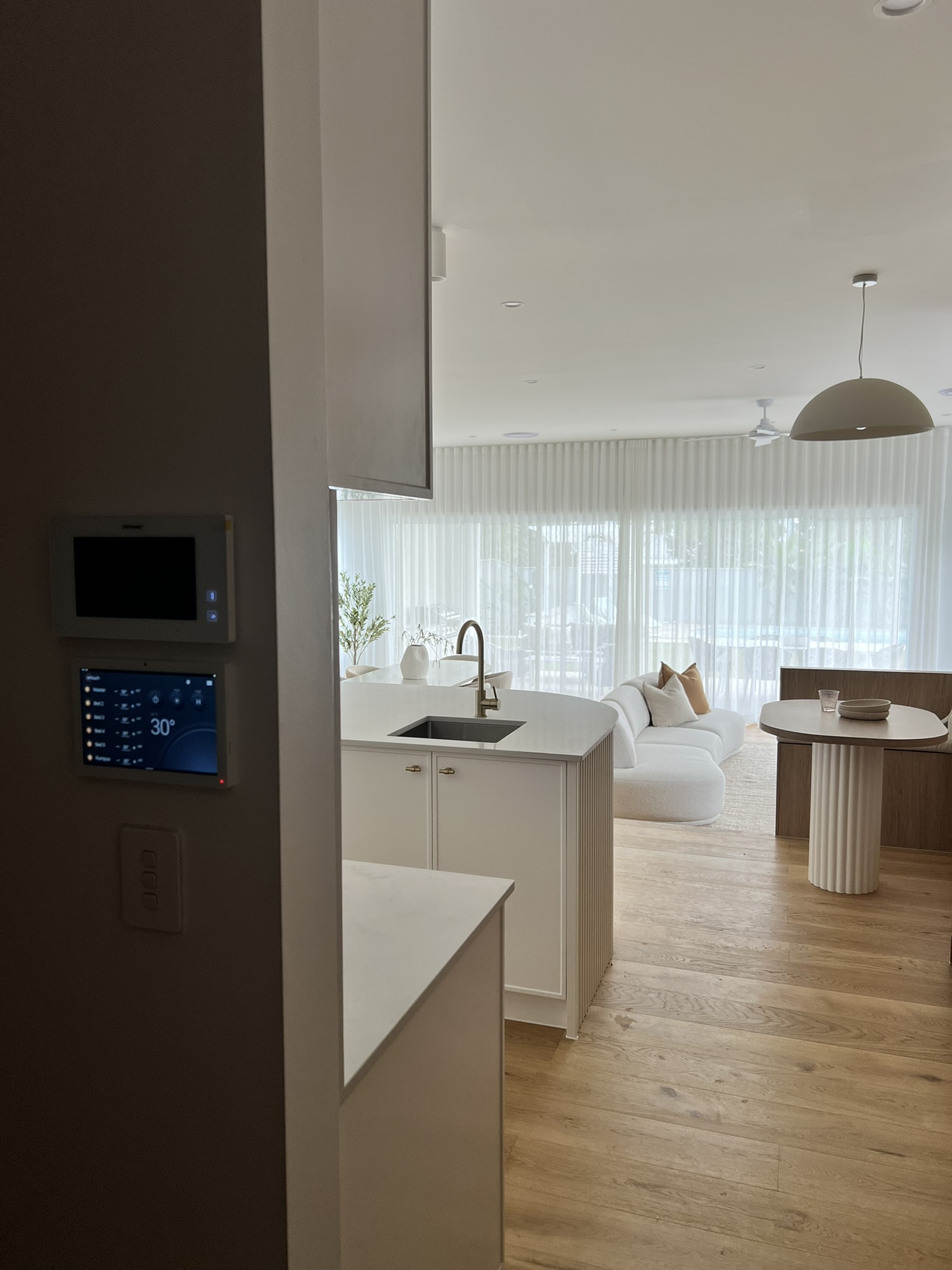 Modern home interior showing air conditioning control panels and a finished living space.